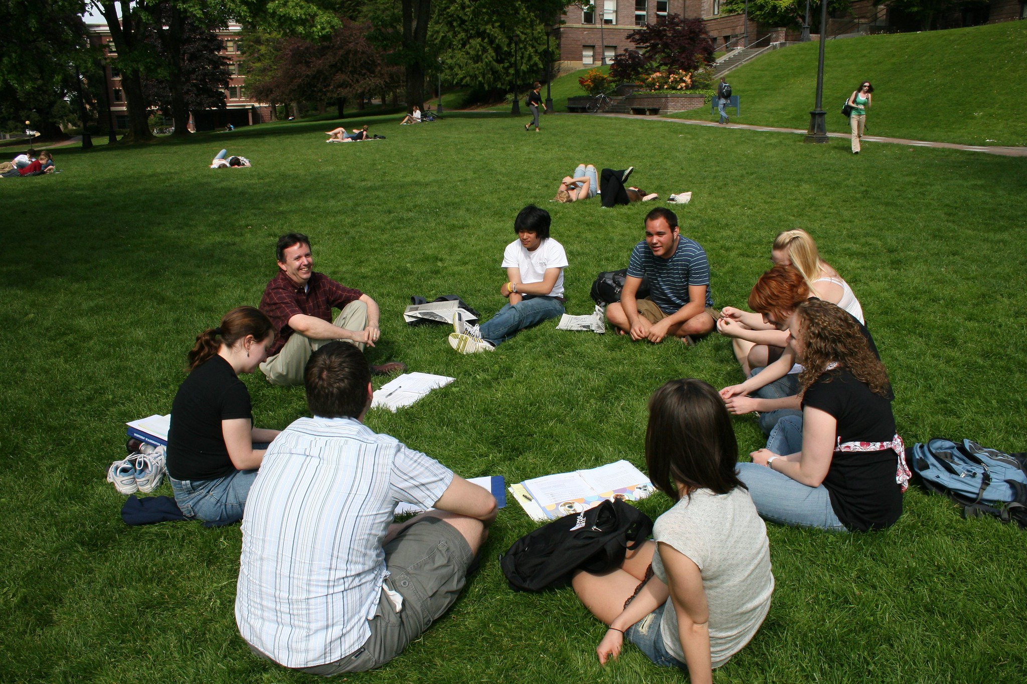 A class gathers outside for a discussion in front of Old Main